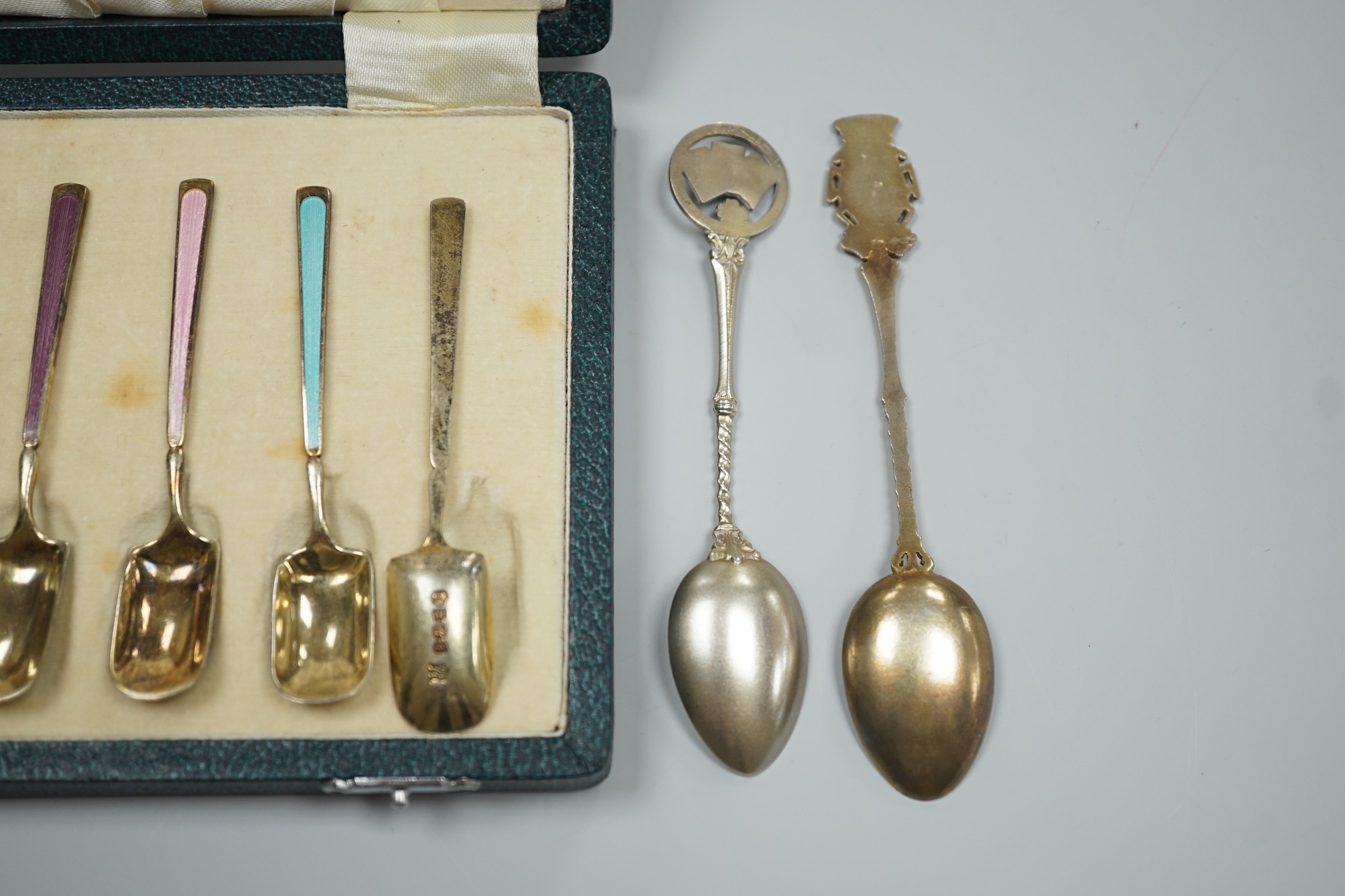 A cased set of six George V silver and polychrome enamel coffee spoons, Barker Bros. Silver Ltd, Birmingham, 1933 and two similar souvenir spoons.